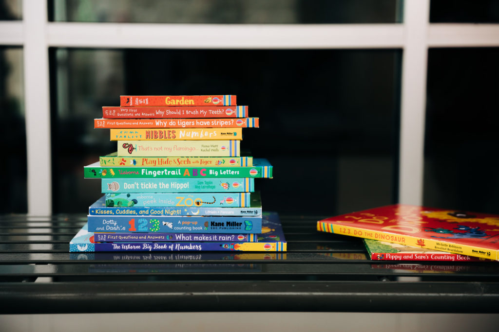 Stack of rainbow books in lifestyle product shot.